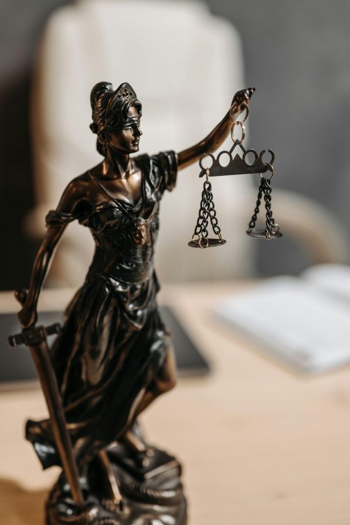 Bronze Lady Justice statue with scales and sword, symbolizing fairness and law.